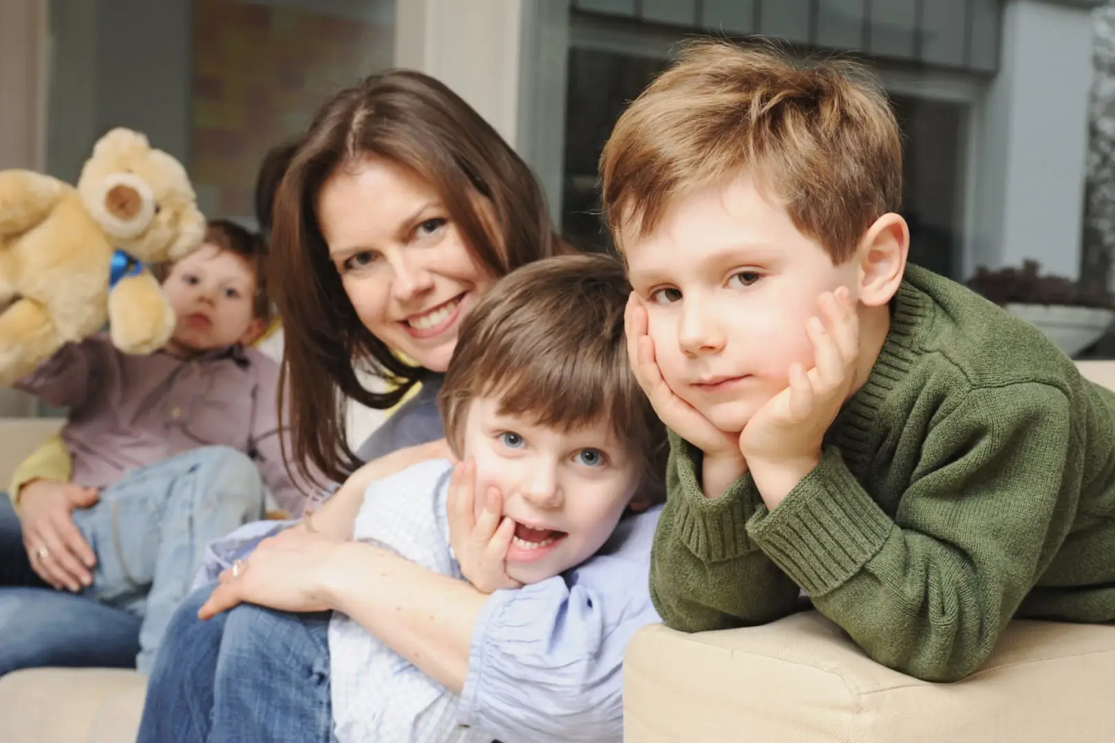 Familie, die glücklich in die Kamera schaut, nachdem Mutter nach Elternzeit durch Jobcoaching wieder einen Job hat.