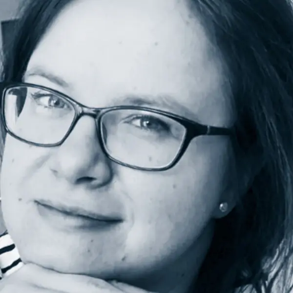Portrait von Katrin Dschjedzik mit Brille, lächelt sanft, engagiert bei AVGS-Coaching für Gesundheit und Job.