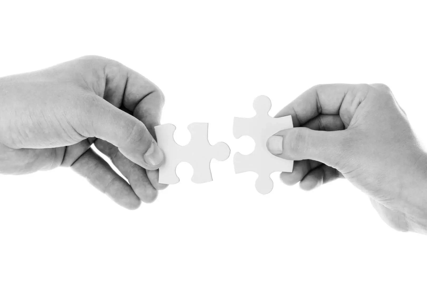 Zwei Hände fügen ein weißes Puzzlestück zusammen, symbolisch für die Lösungsfindung und Zusammenarbeit im Gesundheitscoaching in Hannover.